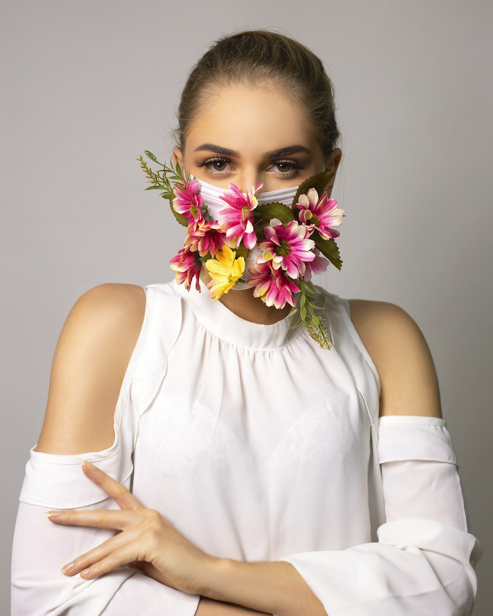 woman in white sleeveless shirt with purple and yellow flower on her head