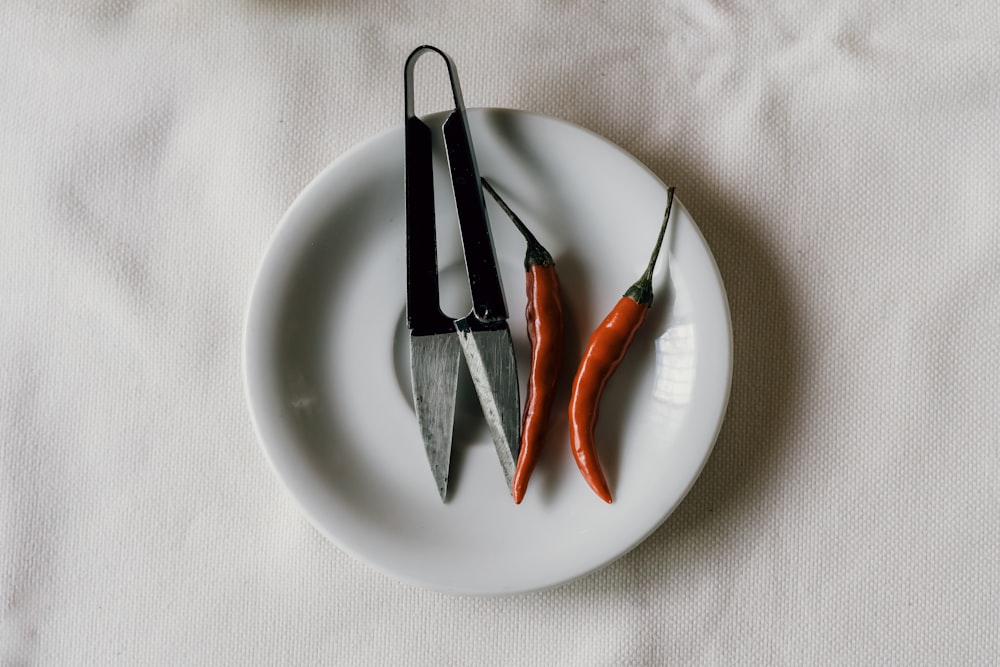 stainless steel fork and bread knife on white ceramic plate