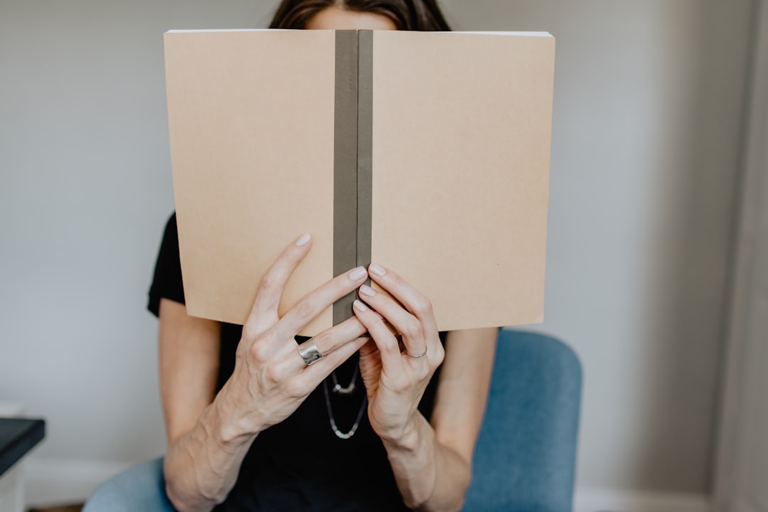 woman in blue shirt holding white book