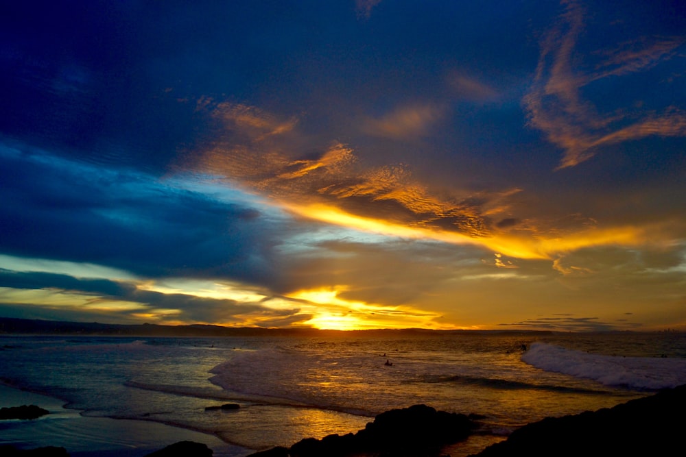 body of water under blue sky during sunset