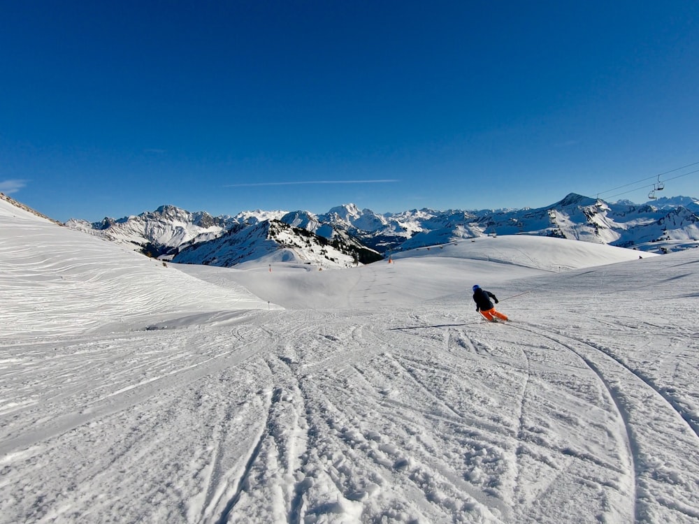 person in red jacket riding on red and black ski board on snow covered mountain during