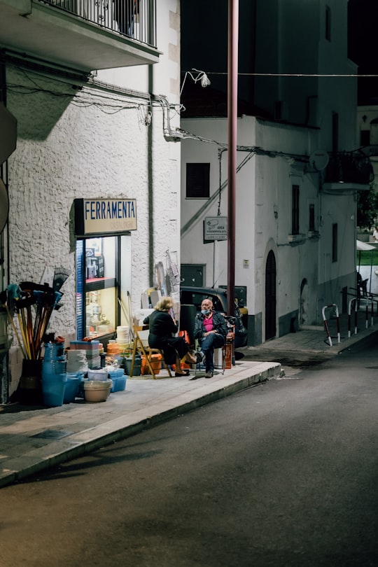 people sitting on sidewalk near building during daytime in Vieste Italy