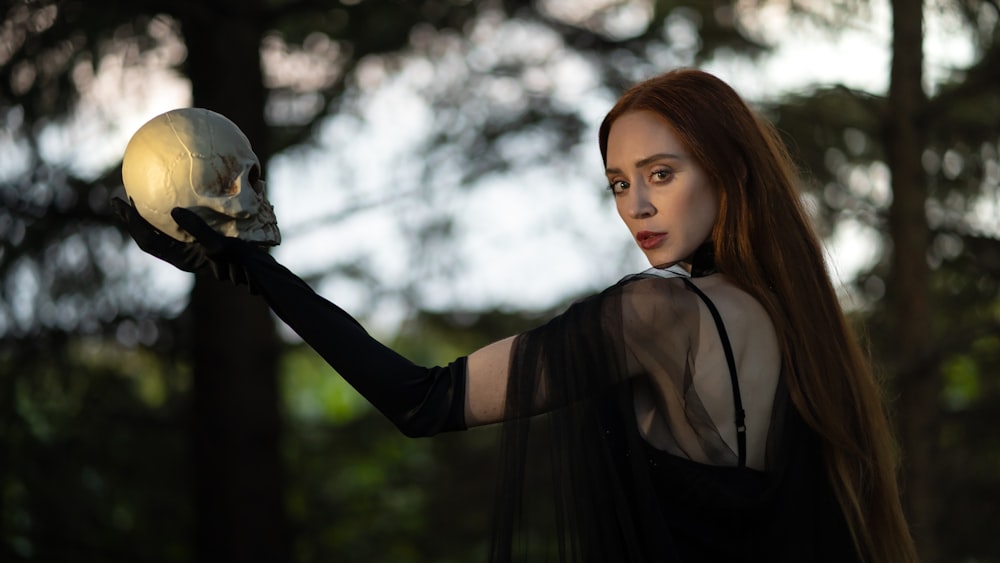 woman in black long sleeve shirt holding white bird