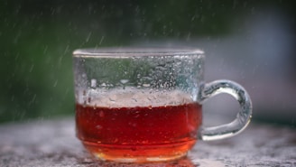 Close-up shot of a glass cup filled with amber-colored sweet Solo tea with condensation drops
