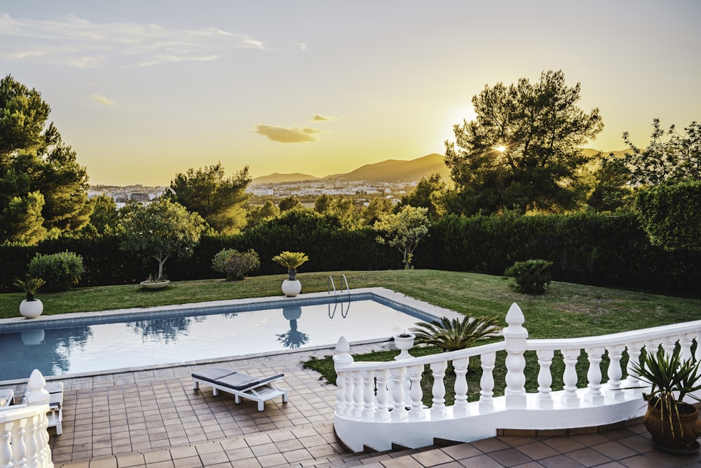 white outdoor pool near green trees during sunset