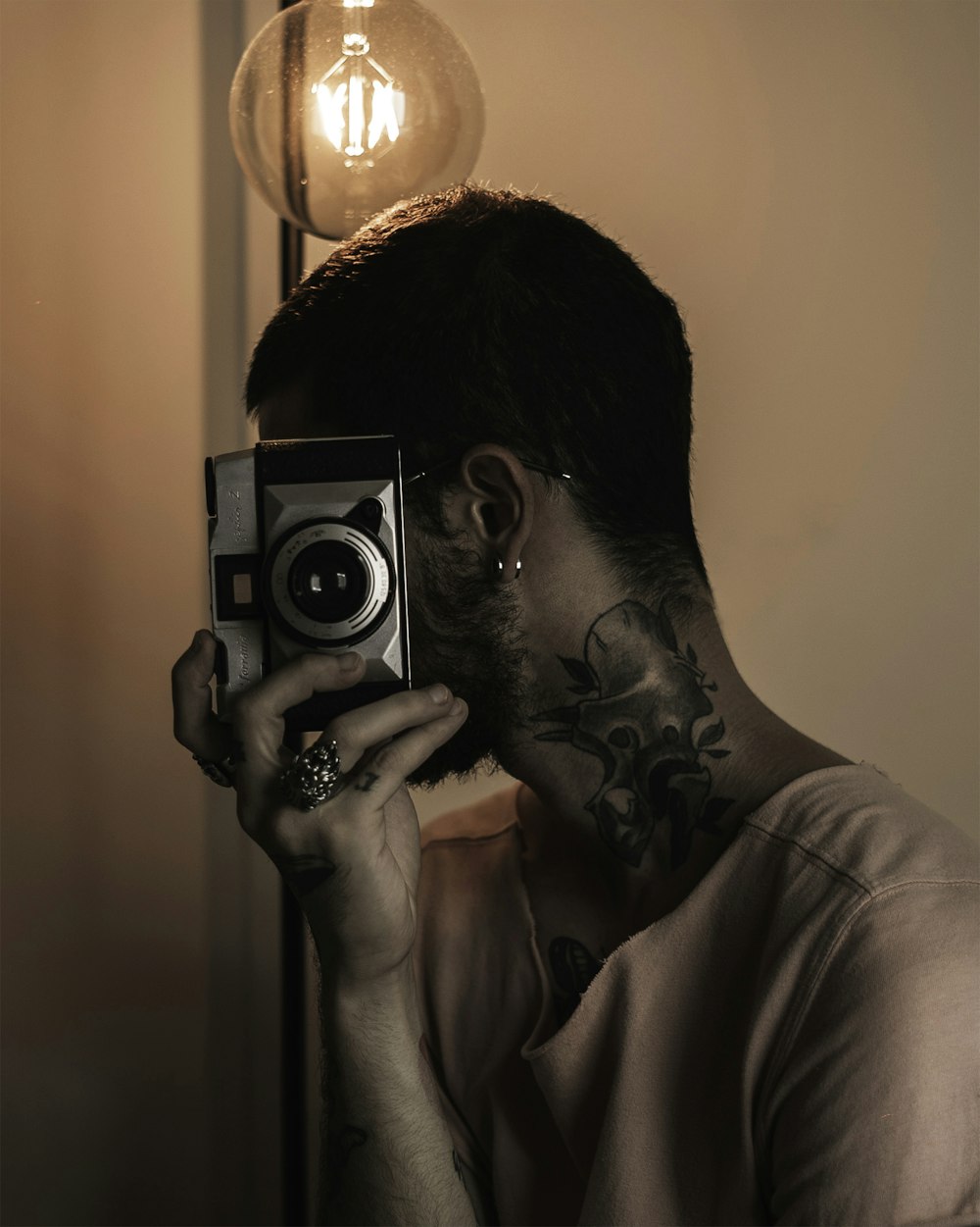 man in white shirt holding camera