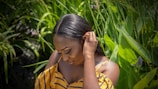 Close-up of someone gently holding an auriwell ear leaf product against their ear with soft natural lighting