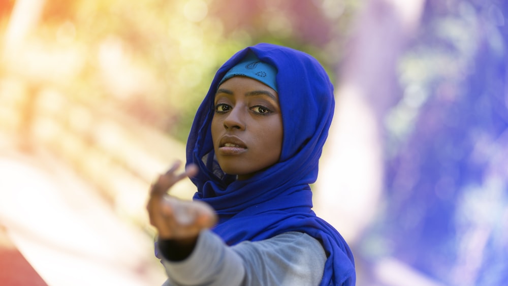 donna in hijab blu e camicia bianca a maniche lunghe