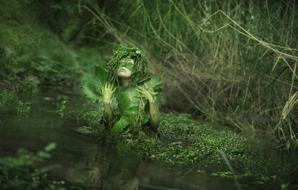 green frog on body of water