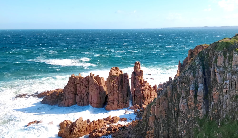 brown rock formation on sea during daytime