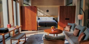 brown wooden table near white bed