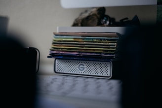 A stack of velvet-covered e-readers glowing softly in a dimly lit room.
