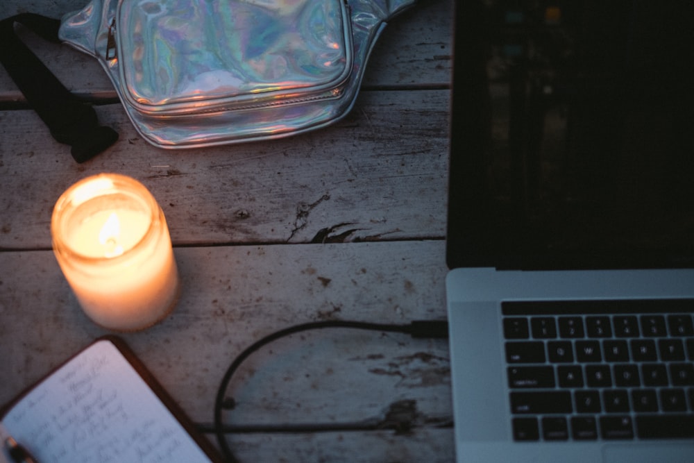 clear glass container beside white laptop computer