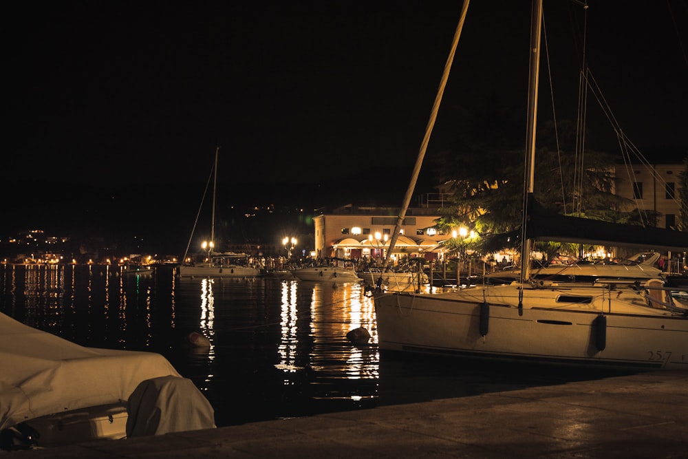 Barco blanco y marrón en el muelle durante la noche