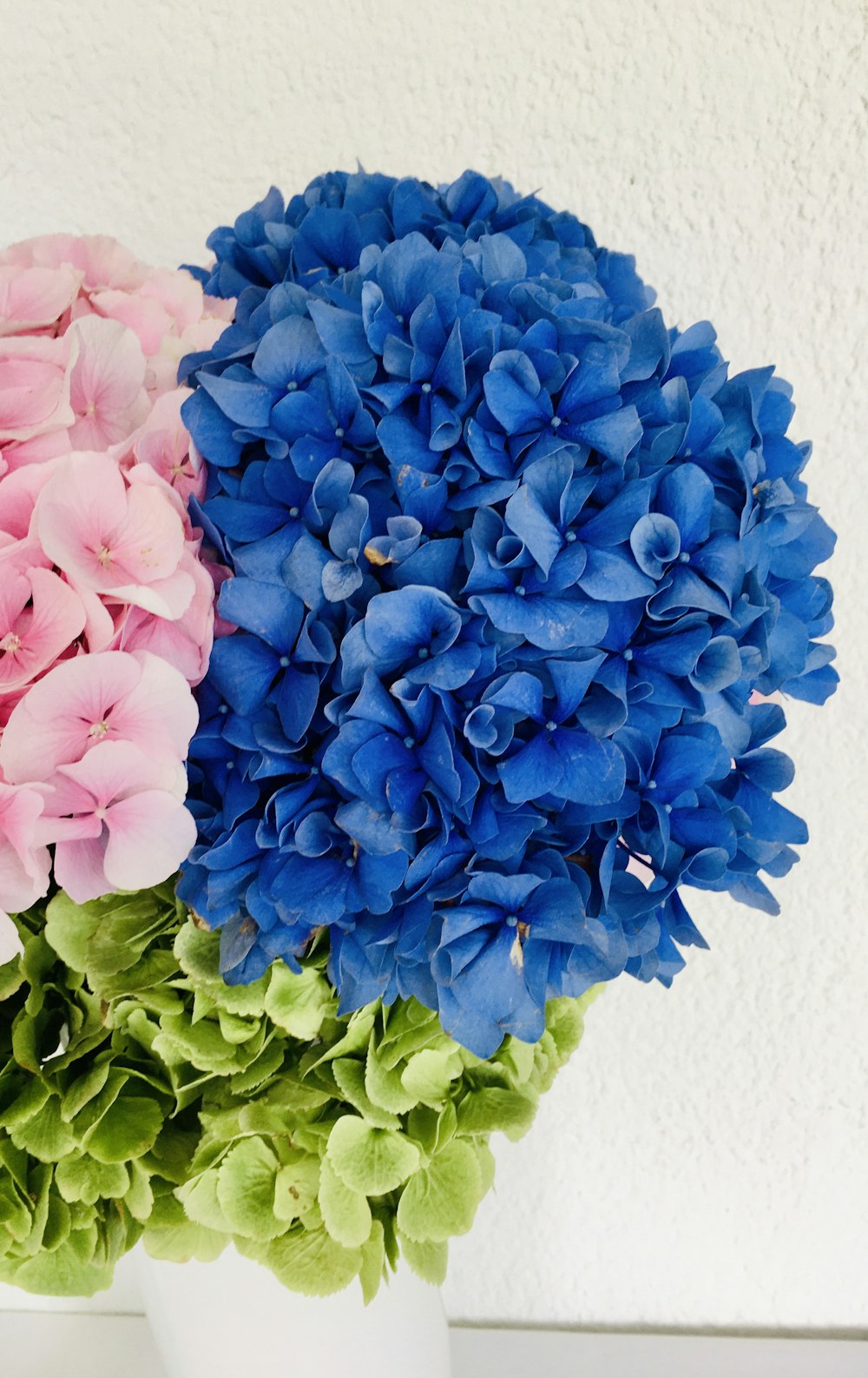 Blauer Blumenstrauß auf weißem Tisch