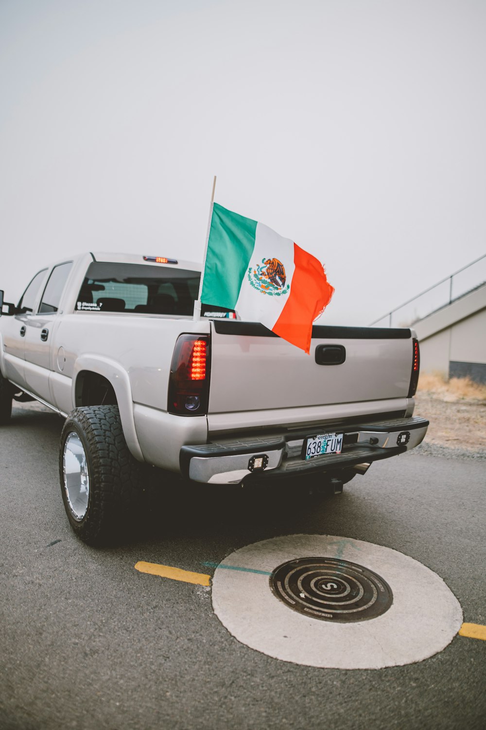 white chevrolet crew cab pickup truck with red flag on top