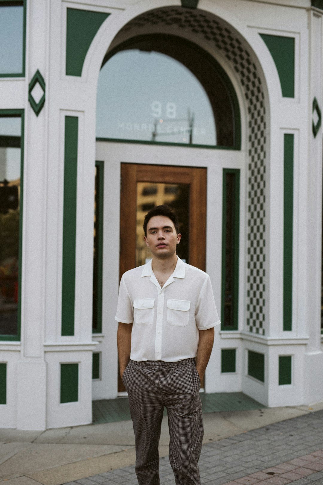man in white button up shirt standing near white wooden door