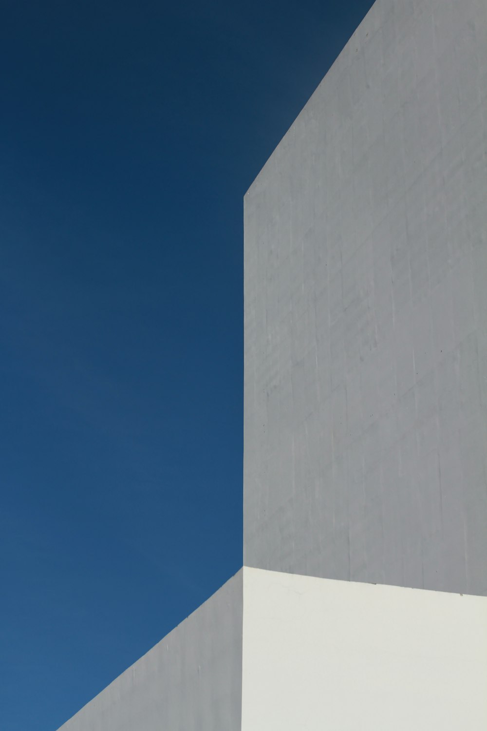 昼間の青空に白いコンクリートの建物