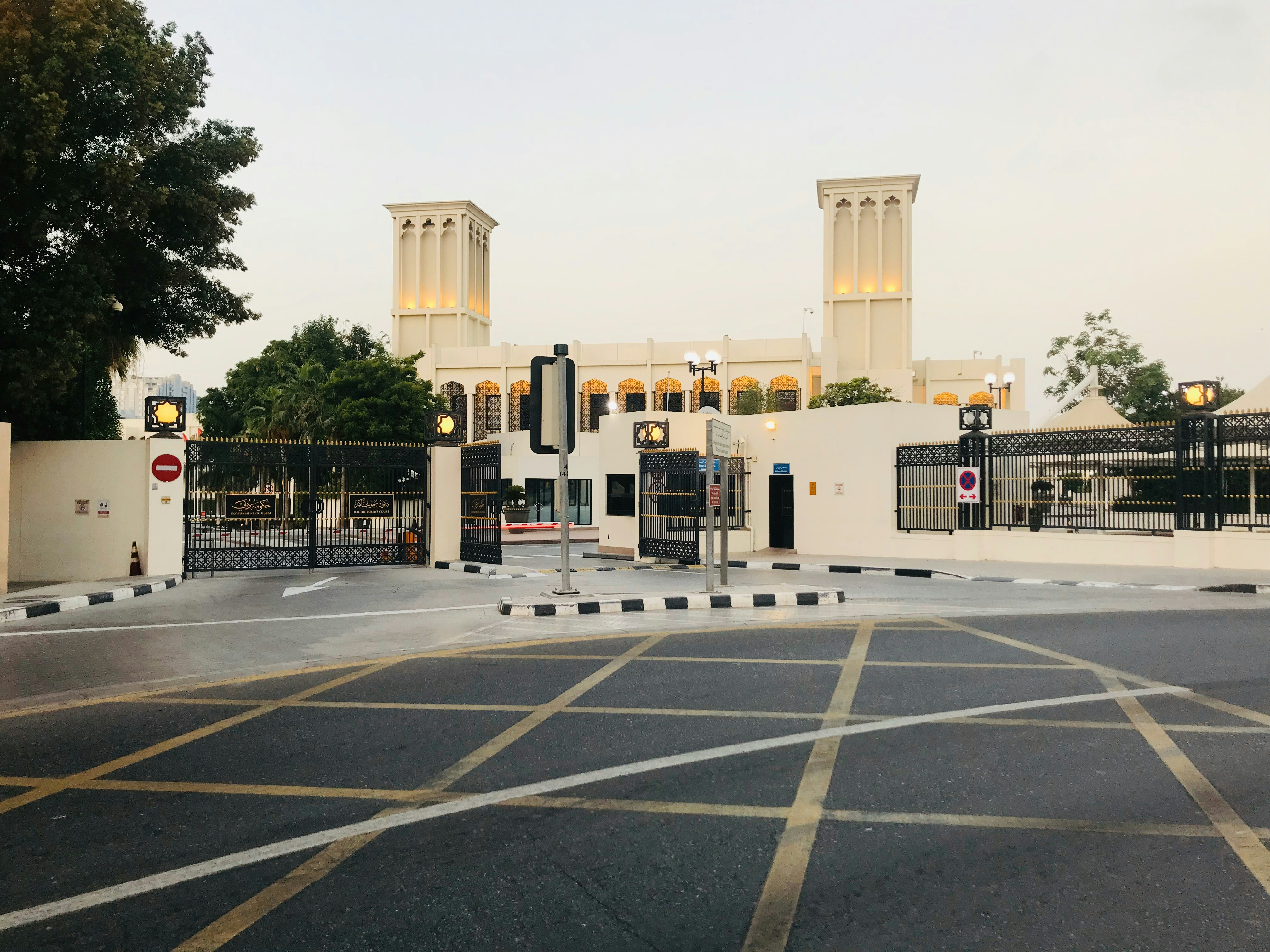 bangunan beton putih di dekat pohon hijau di siang hari