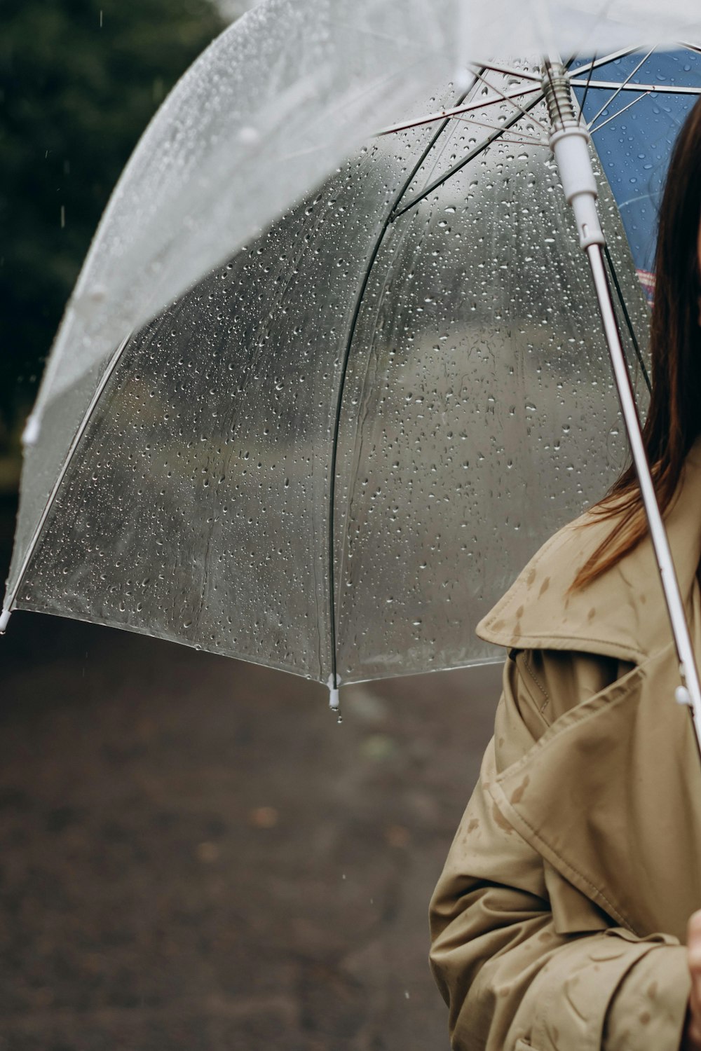 person in brown coat holding umbrella