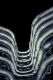 A sleek, illuminated model of a futuristic building merging organic curves with sharp geometric lines.