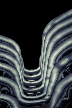 A sleek, illuminated model of a futuristic building merging organic curves with sharp geometric lines.