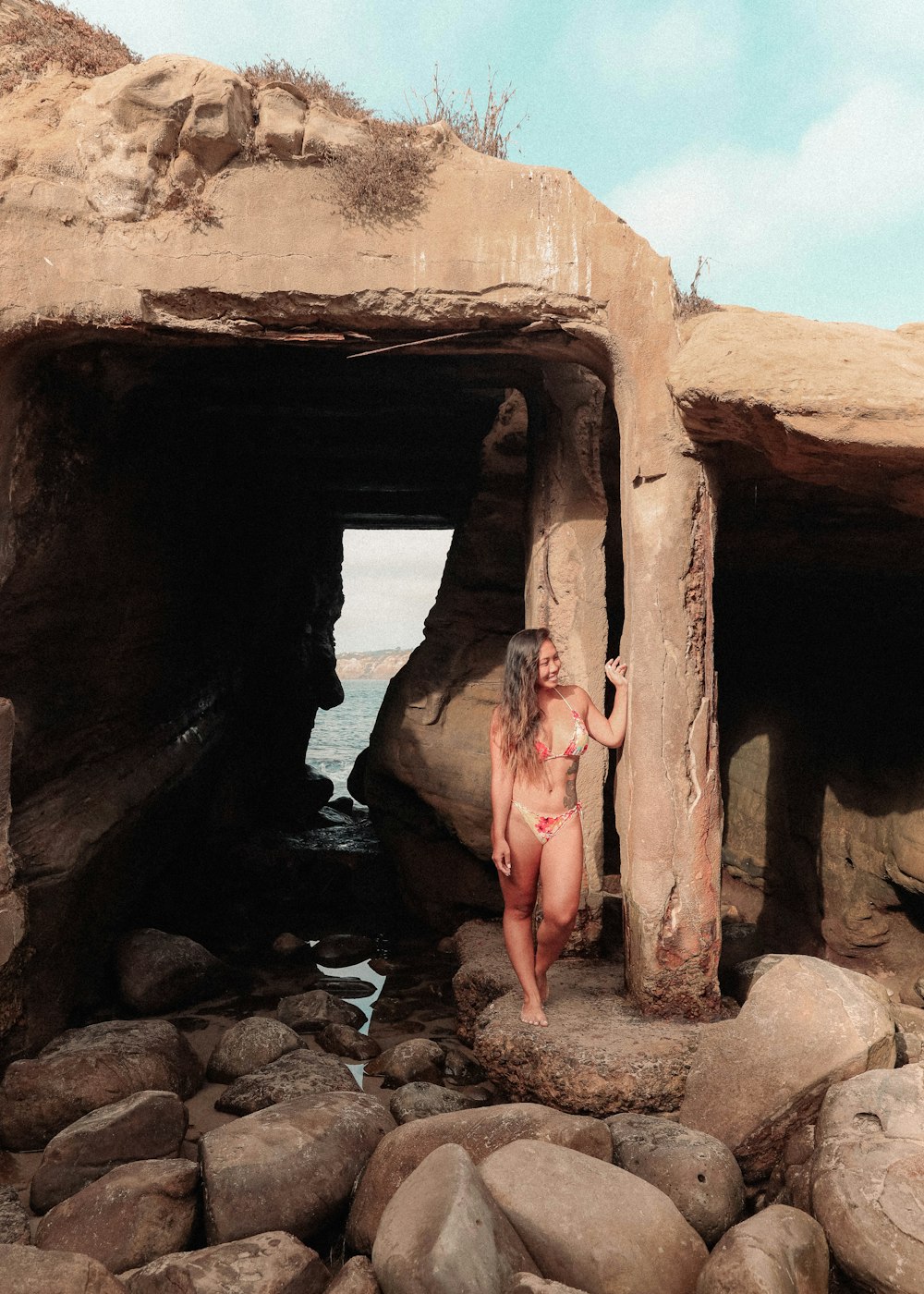 woman in black bikini on brown rock formation during daytime