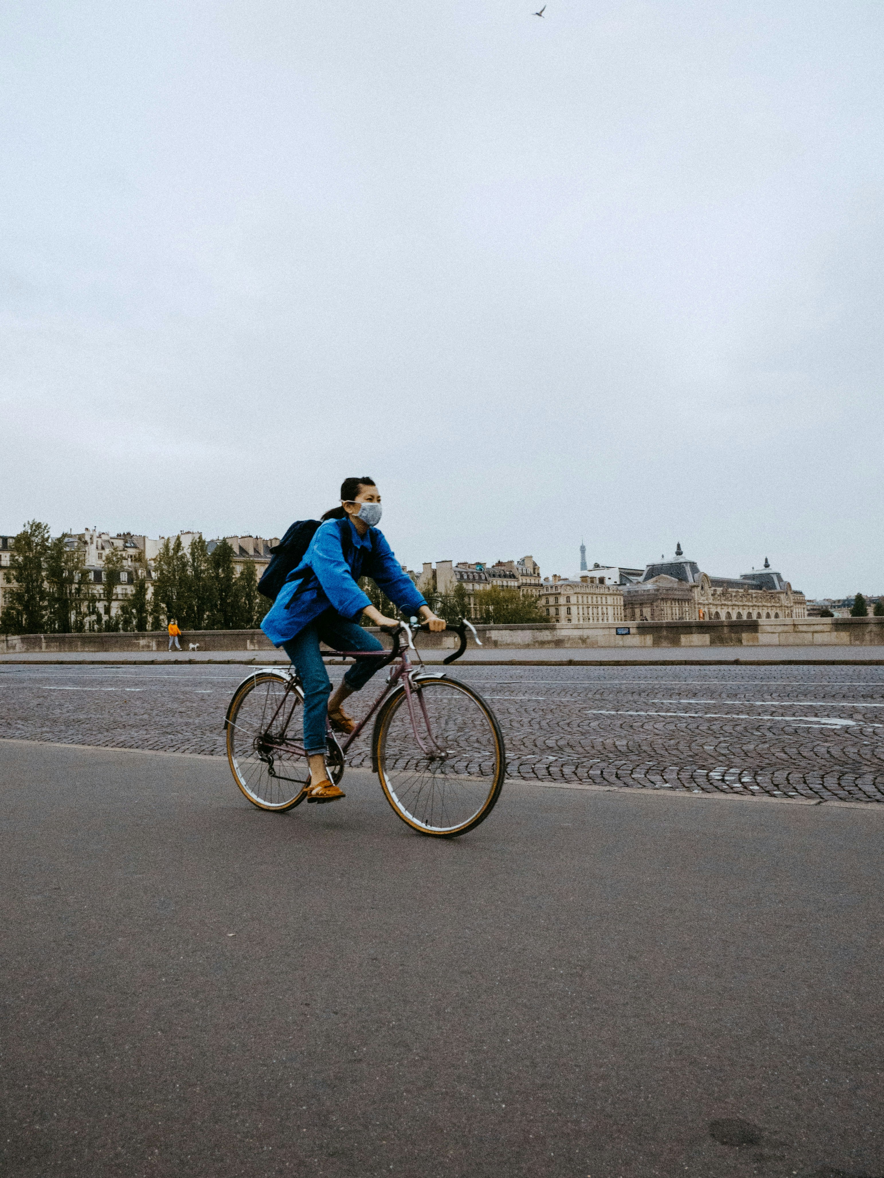 man in blue jacket riding bicycle on road during daytime