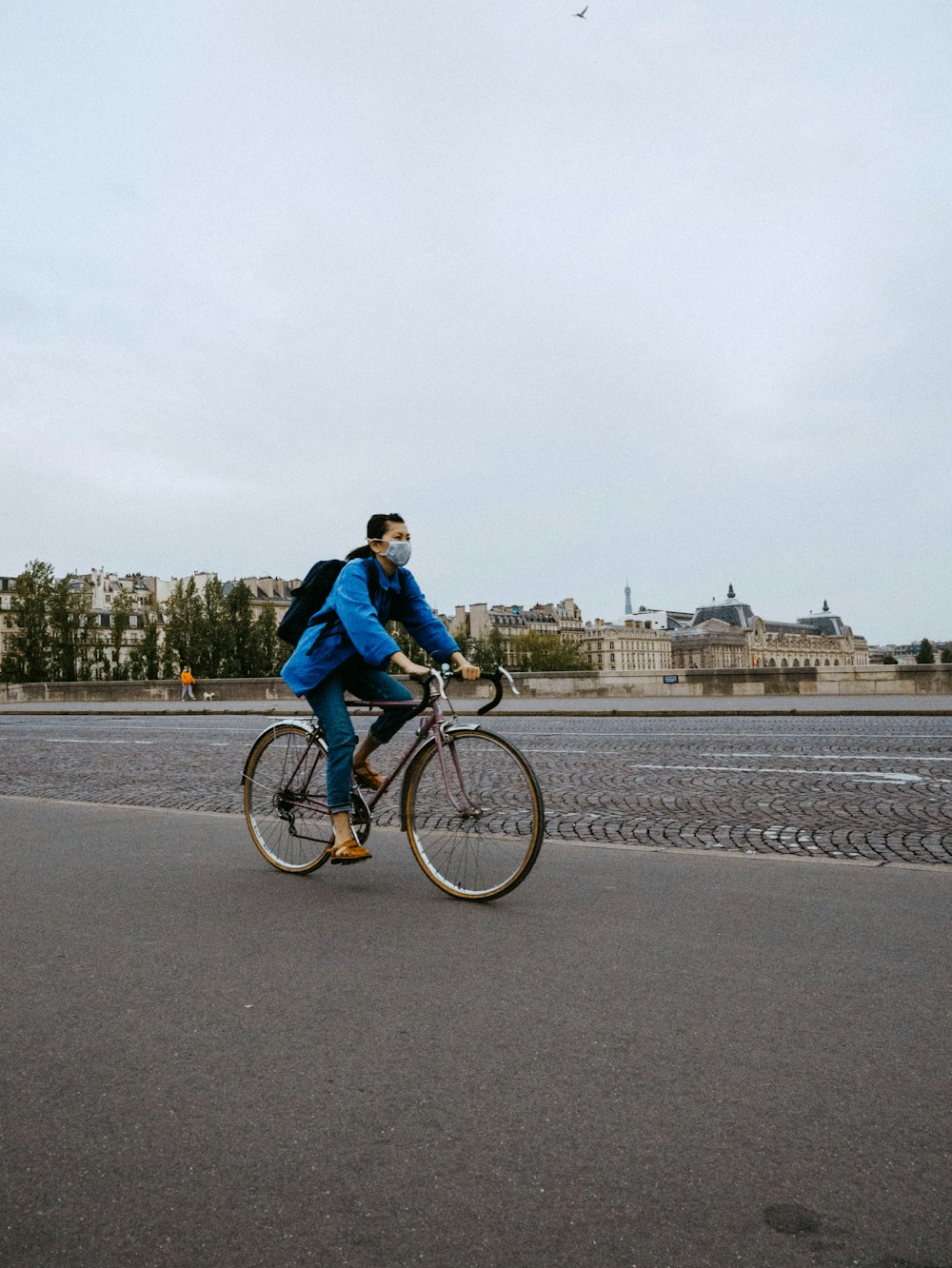 낮 동안 도로에서 자전거를 타는 파란 재킷을 입은 남자