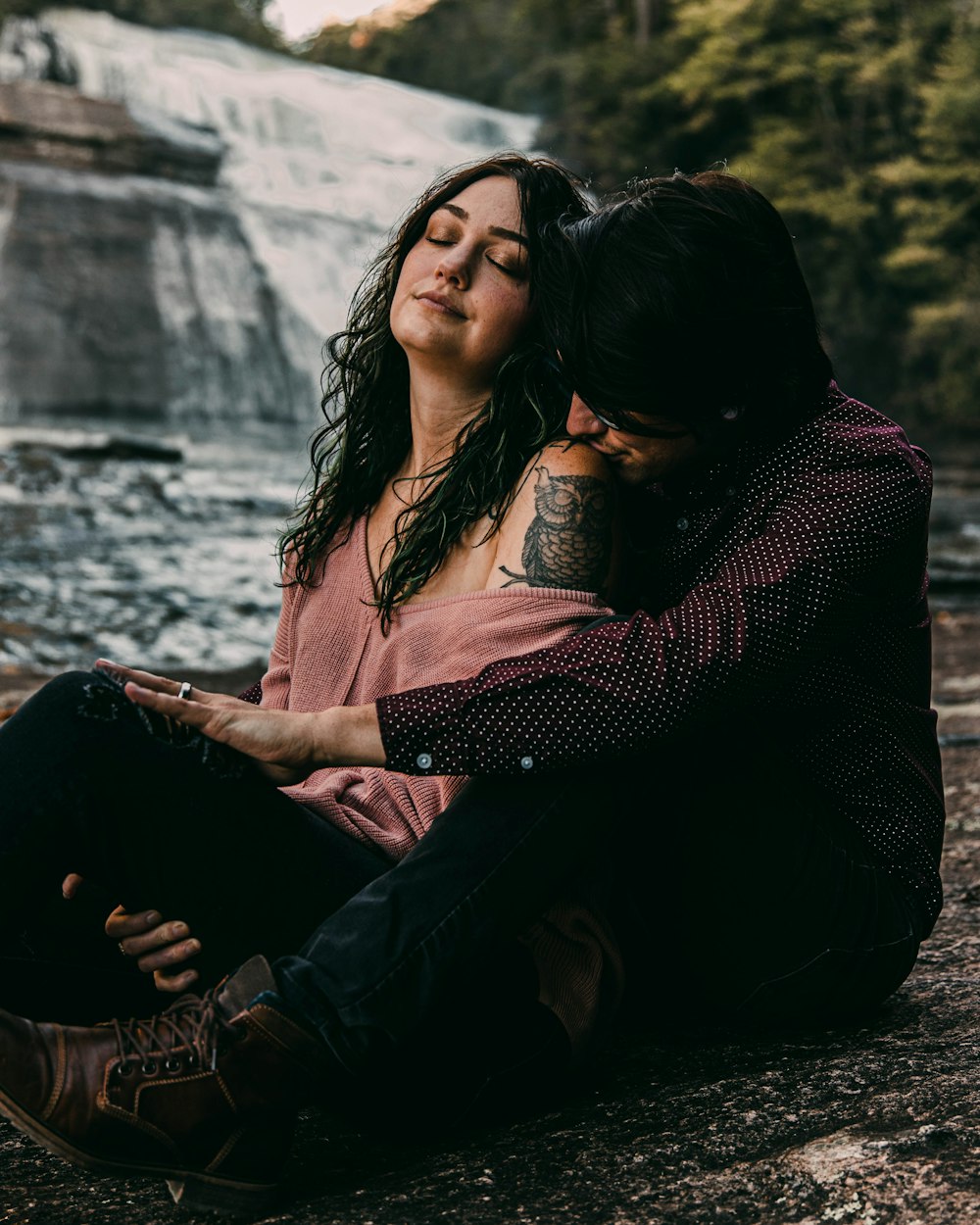 man and woman sitting on rock during daytime