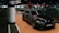 A sleek, black BMW car is parked in a dimly lit underground parking lot. The car is positioned near a column labeled H8. The setting has a modern and somewhat industrial feel with various overhead lights and another car visible in the background.