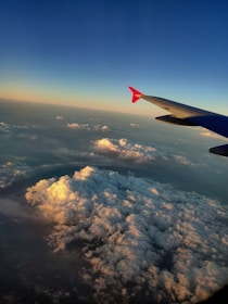 A serene airplane wing cutting through a golden sunset sky.