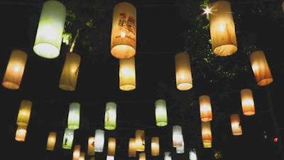Sunlight filtering through handmade paper lanterns glowing softly.