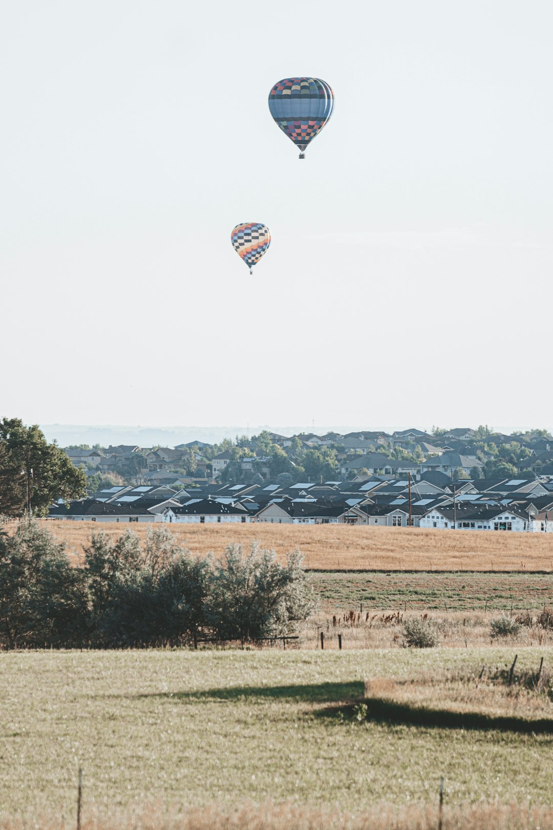 hot air balloon flying over green grass field during daytime