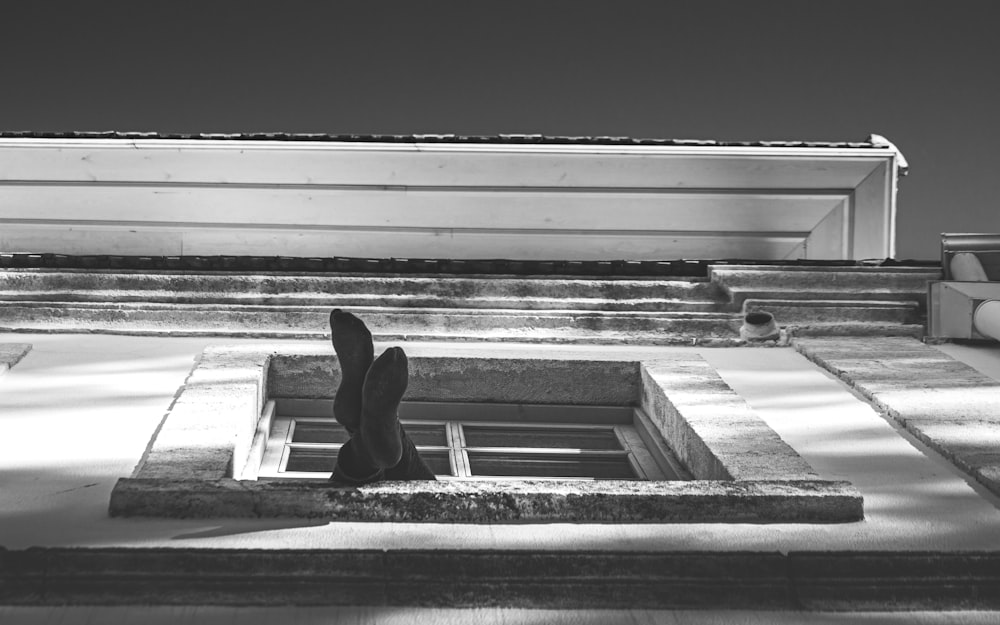 grayscale photo of person sitting on stairs