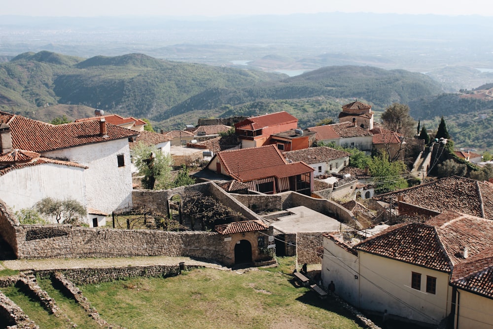 Maisons en béton blanc et brun près d’un champ d’herbe verte pendant la journée