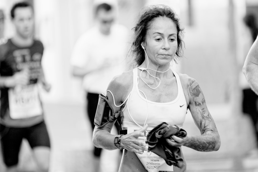 woman in white tank top holding black dslr camera