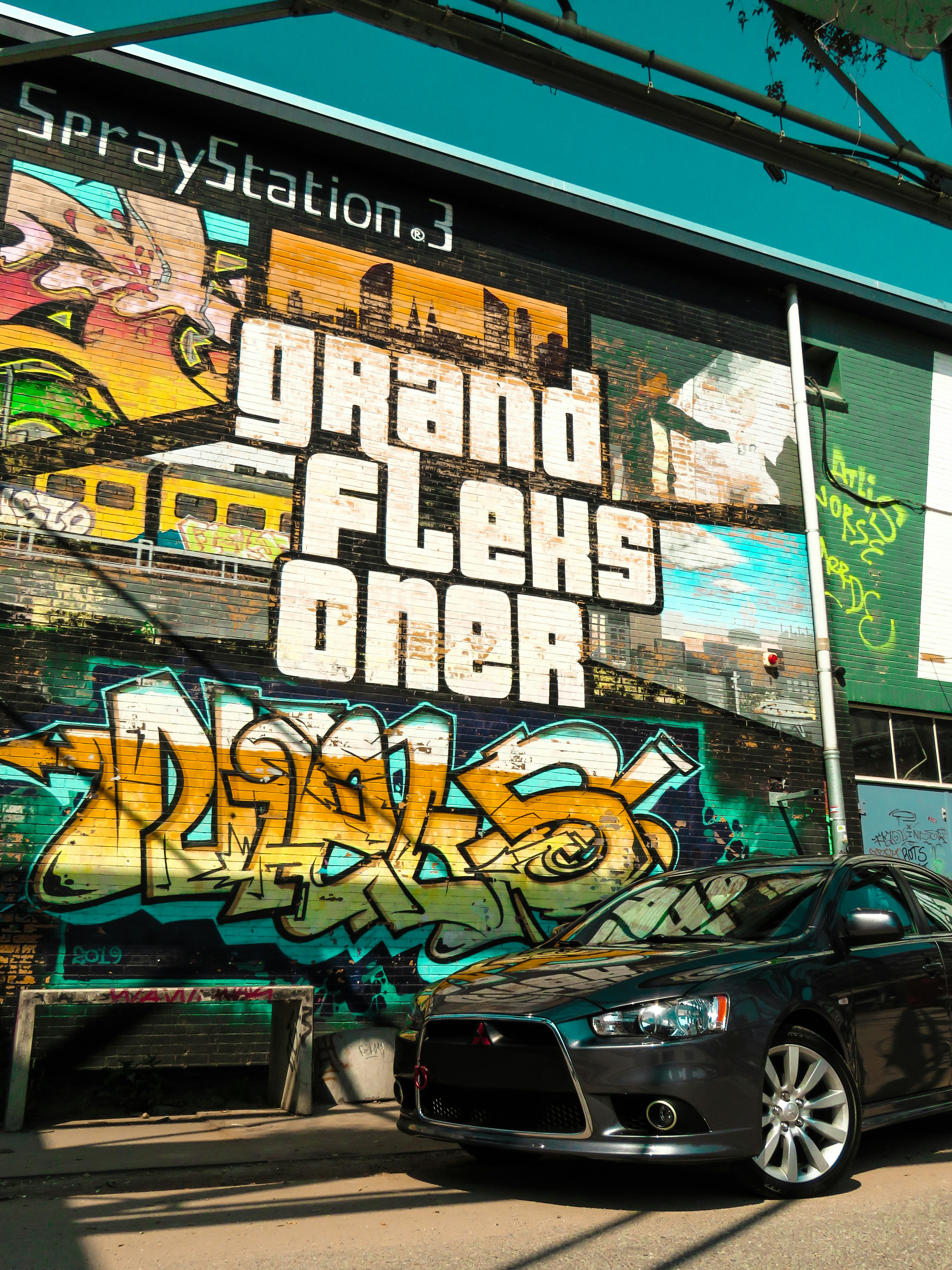 black suv parked beside wall with graffiti