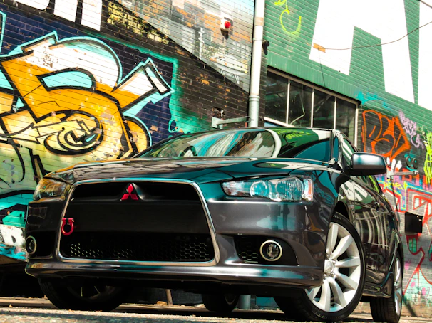 Vibrant vehicle wrap on a sleek black car parked in downtown Lawrenceville.