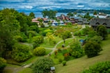 Garden area with vibrant flowers and stone pathways surrounded by hill scenery.
