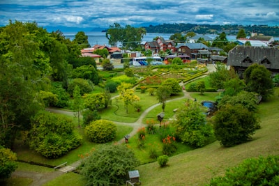 Garden area with vibrant flowers and stone pathways surrounded by hill scenery.