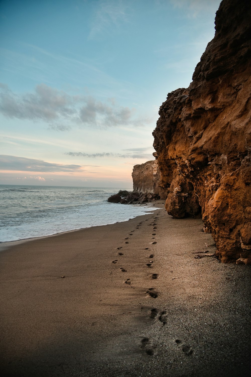 brown rock formation near body of water during daytime