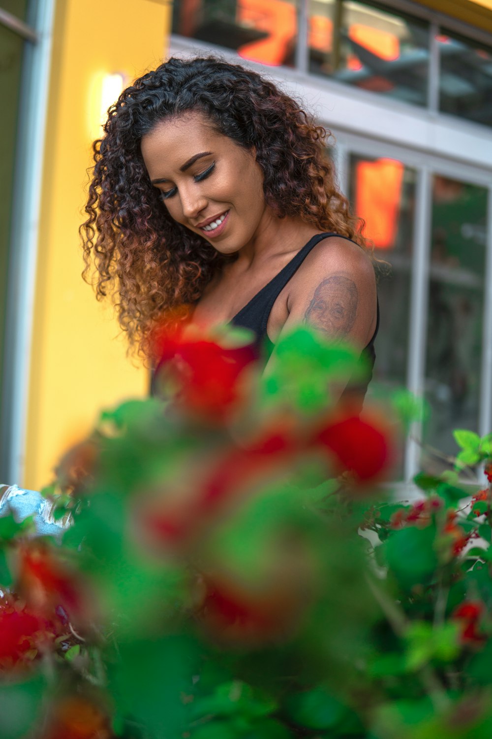 woman in black tank top holding red rose