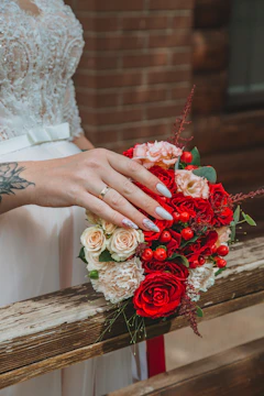 Close-up of a handcrafted bridal bouquet featuring peach and nude roses with cream accents.