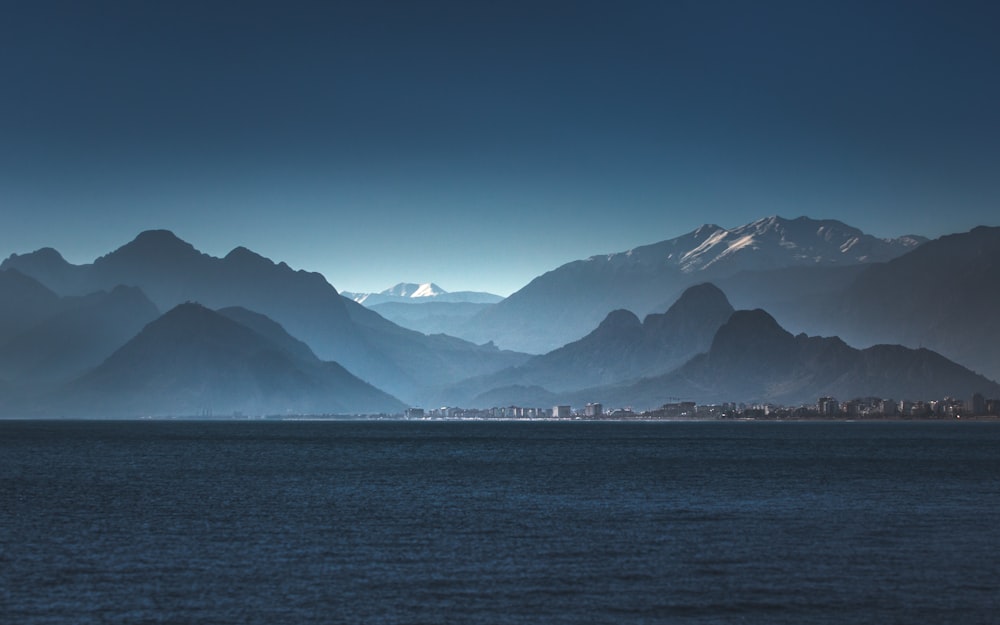 specchio d'acqua vicino alle montagne durante il giorno