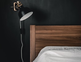 black and white table lamp on brown wooden nightstand