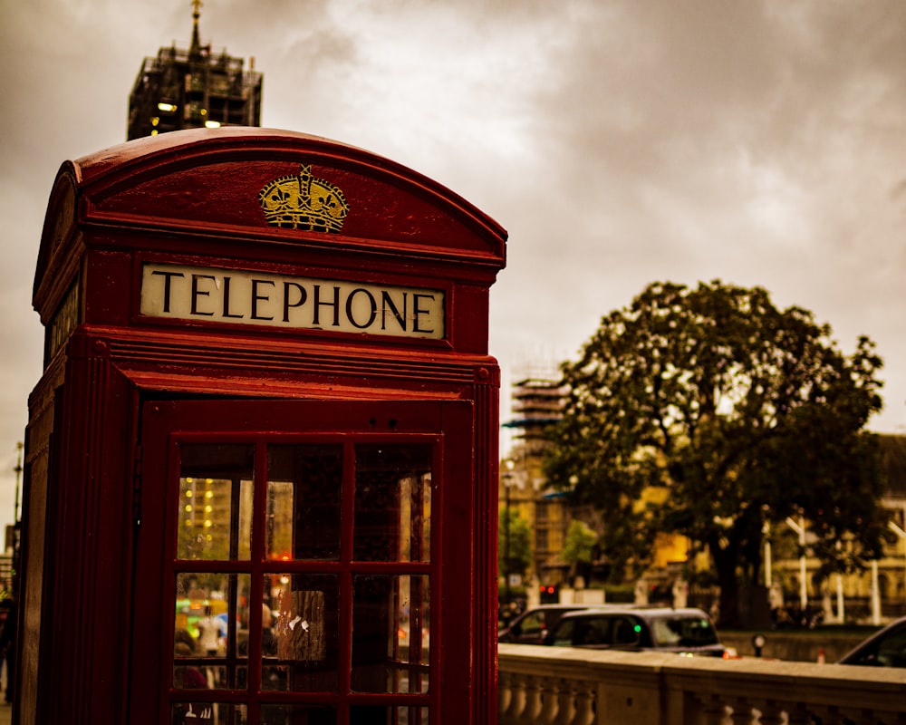 Cabina telefonica rossa vicino alla strada durante il giorno