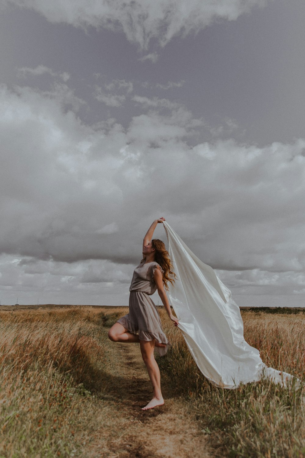woman in white dress standing on brown grass field