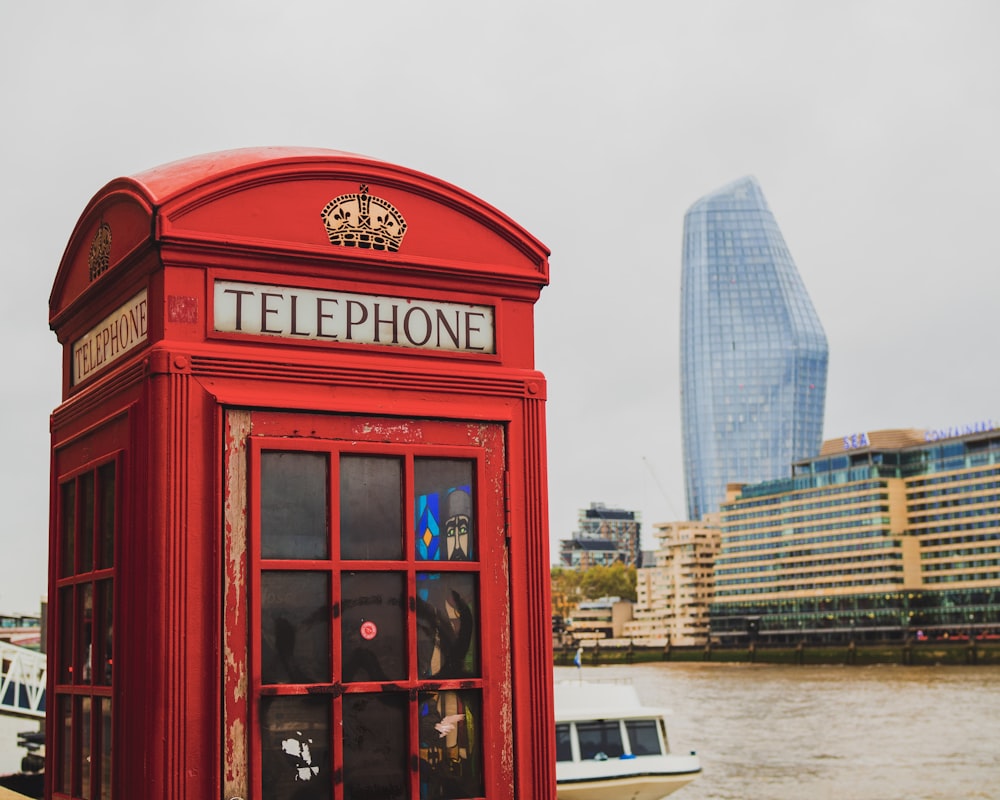 red telephone booth near high rise building during daytime