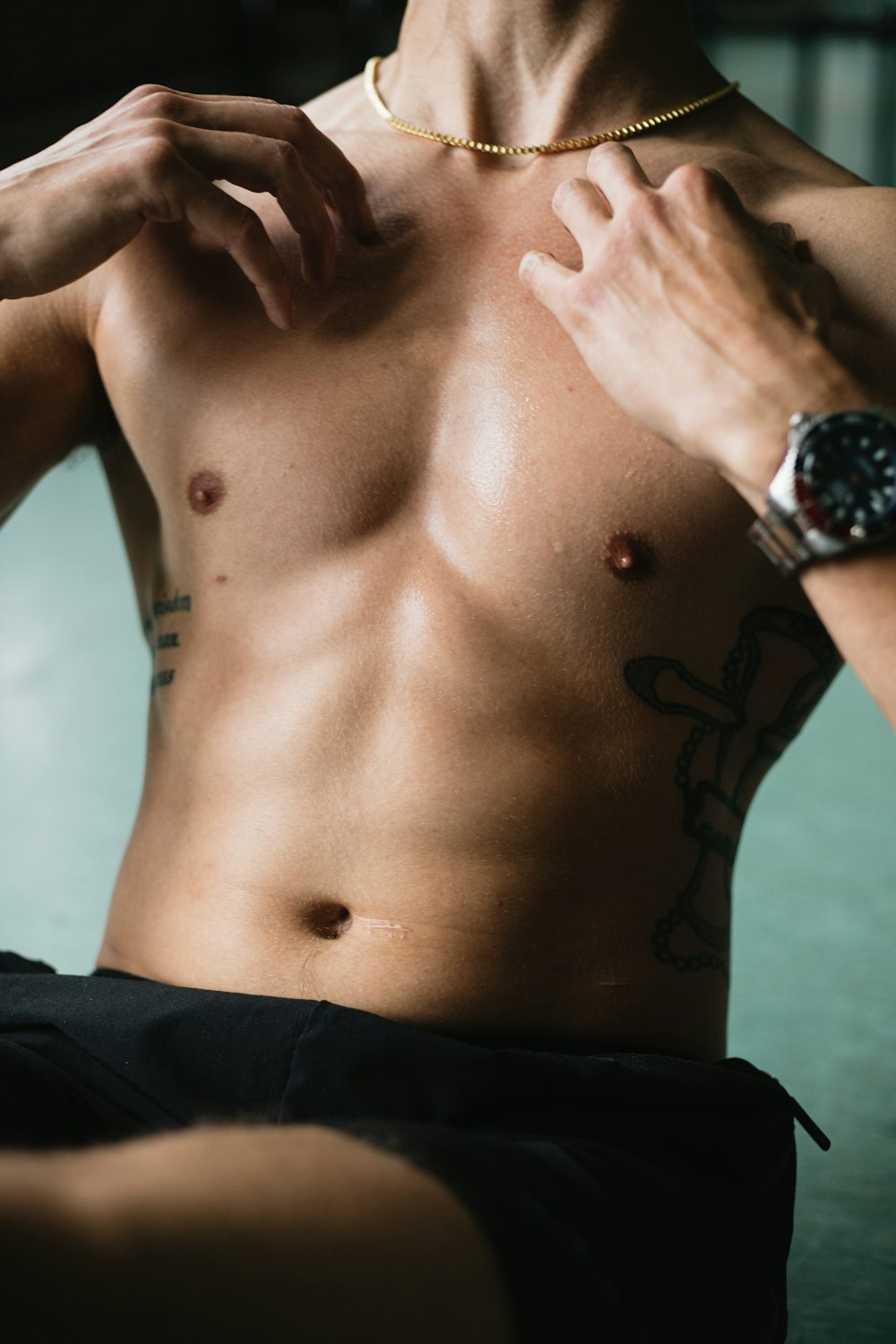 topless man wearing silver link bracelet round analog watch